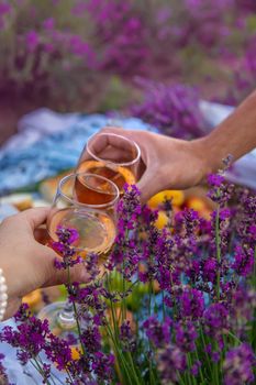 A woman and a man drink wine in a lavender field. Selective focus. Food.