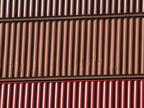 Close-up of Shipping containers stacked on top of each other of different colors of red and orange.