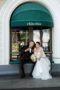 bride and groom near the cafe on the street of the summer city