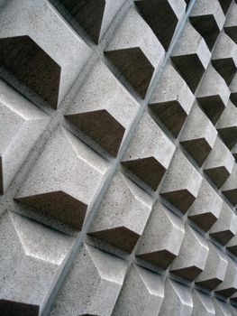 Grey Square concret shapes project out of side wall of building.