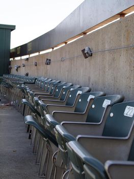 Row of green seats in the top row of the upperdeck of stadium
