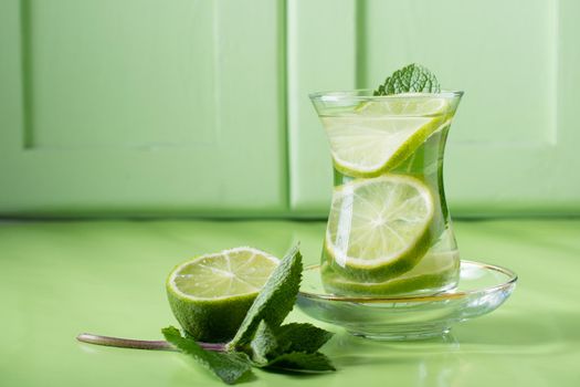 tea with mint and lime, with a calming effect, green still life close-up on a green background, top view. mojito, health drink, alternative medicine.High Quality Photo