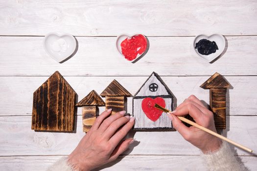 female hands draw a heart on a wooden house, crafting, step by step instructions how to make decor for valentine's or mother's day, Sweet Home. High quality photo