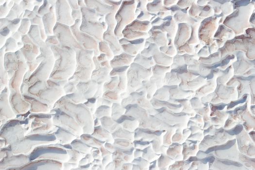 Background white texture of Pamukkale calcium travertine in Turkey, abstract pattern, top view.