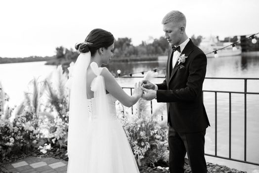 wedding ceremony on a high pier near the river with invited guests