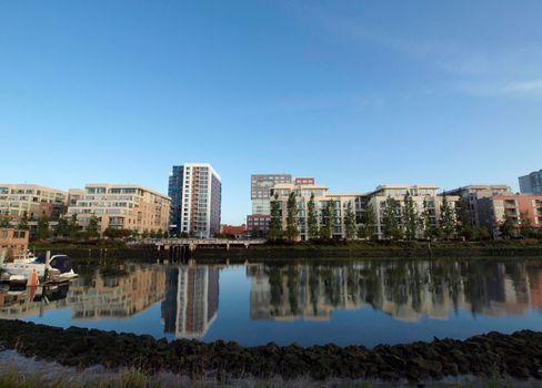 Mission Creek Park waterway with houseboats and modern buildings on a nice day.