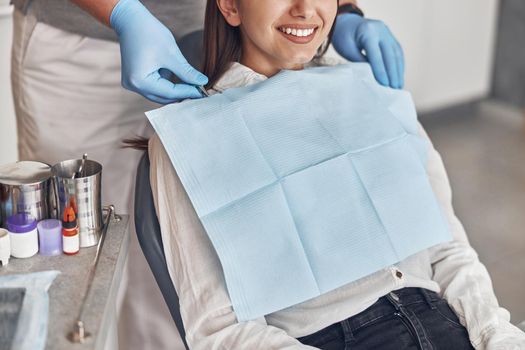 Confident male doctor is preparing young woman to dental survey