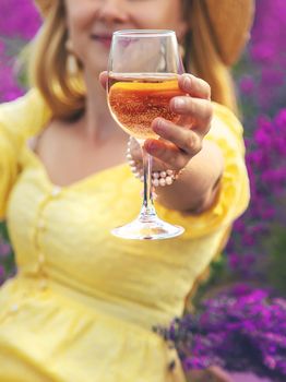 A woman drinks wine in a lavender field. Selective focus. Food.