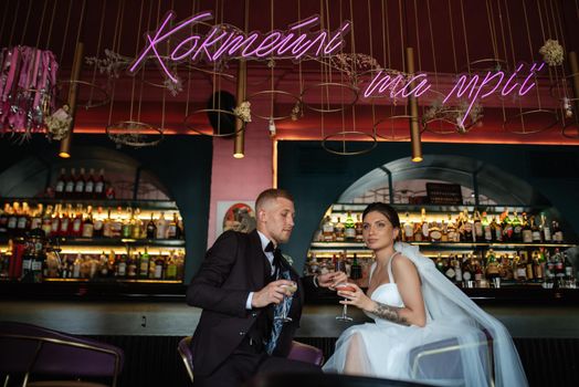 bride and groom inside a cocktail bar in a vibrant atmosphere