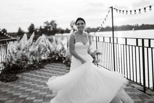 bride against the background of a yellow sunset on a pier near the river