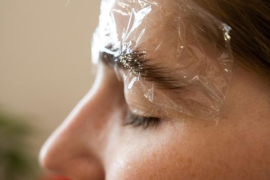 Caucasian woman on the procedure of permanent styling and coloring of eyebrows