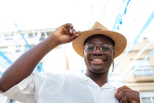 Happy black man wearing a hat smiling looking at camera during holidays abroad. Lifestyle concept.