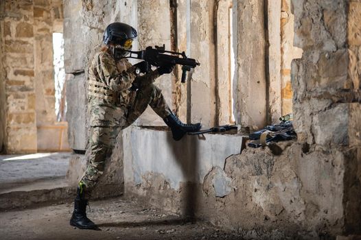 A woman in an army uniform shoots a firearm in an abandoned building