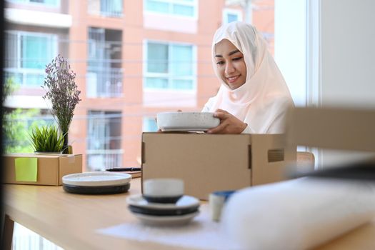 Asian muslim woman in hijab preparing product for shipping to customers. E-commerce, Online selling concept.