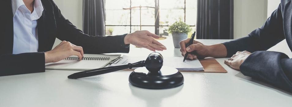 Business woman and lawyers discussing contract papers with brass scale on wooden desk in office. Law, legal services, advice, Justice concept..