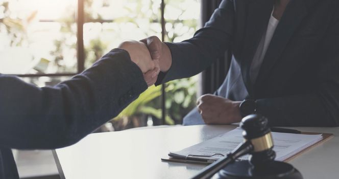 Good service cooperation of Consultation between a male lawyer and business woman customer, Handshake after good deal agreement, Law and Legal concept..