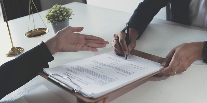 business people and lawyers discussing contract papers sitting at the table. Concepts of law, advice, legal services.