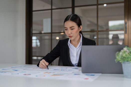 Business woman using calculator for do math finance on wooden desk in office and business working background, tax, accounting, statistics and analytic research concept.