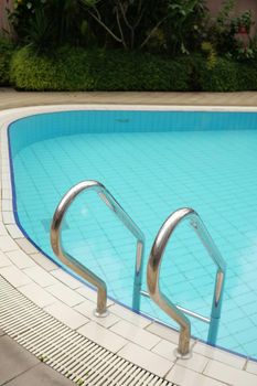 an empty swimming pool with poll stair.