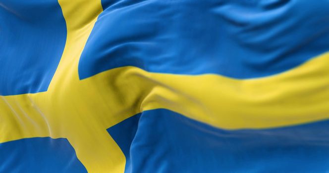 Close-up view of Sweden national flag waving in the wind. Scandinavian country located in northern Europe
