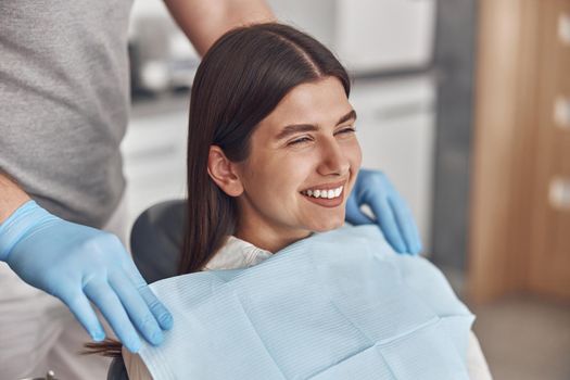 Confident male doctor is preparing young woman to dental survey