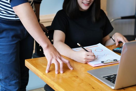 focus hand holding pen point to chart with discussion and exchange of ideas during work