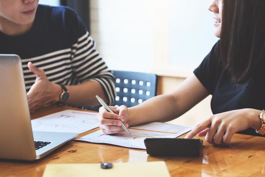 focus hand holding pen point to chart with discussion and exchange of ideas during work.