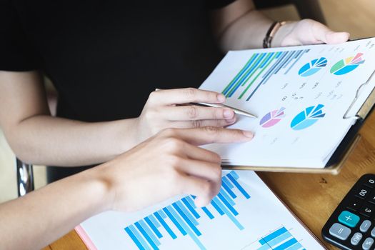 focus hand holding pen point to chart document with business woman and partnership discussion and exchange of ideas during work.