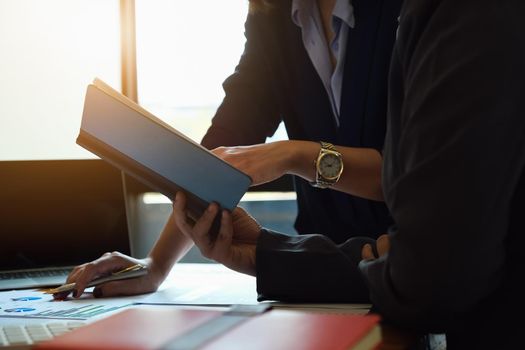 Business consultants using notebook with explaining statistics graphs and ways to increase profits this quarter.