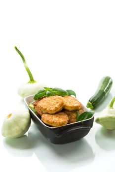 fried vegetable pancakes from squash and zucchini with greens, isolated on a white background.