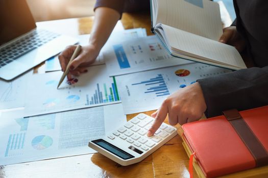 vintage tone effect with business woman using calculator to calculate budget and partnership using computer at work.