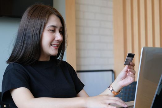 Online payment with Young Women hands holding credit card and using computer for online shopping.