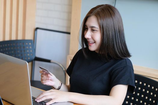 Online payment with Young Women hands holding credit card and using computer for online shopping.