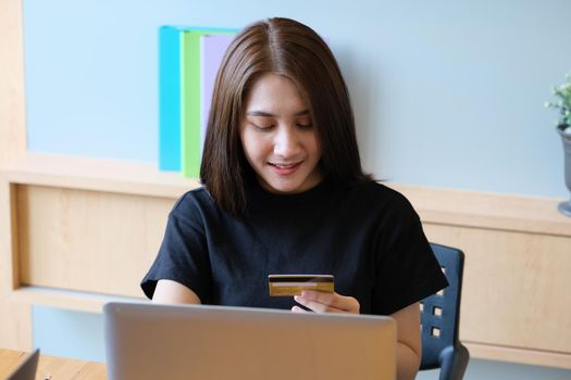Online payment with Young Women hands holding credit card and using computer for online shopping.