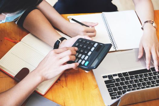 vintage tone effect with business man using calculator to calculate budget and partnership using computer at work.