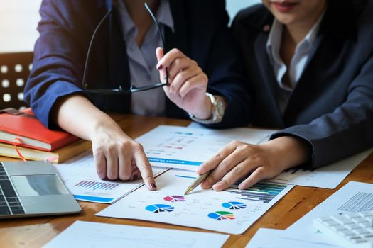 focus hand holding pen point to chart with discussion and exchange of ideas during work