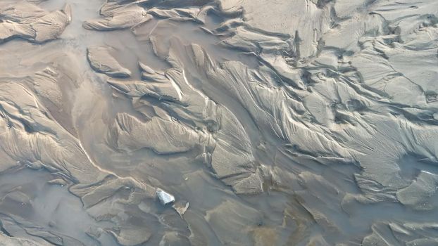 Dirty wet sand, grunge horizontal shabby background close-up. Blurry image of sand pattern. Abstract nature background.