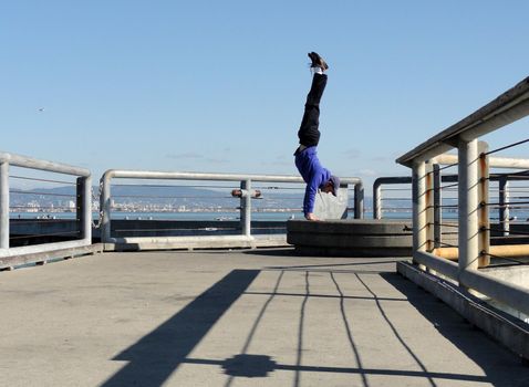 Man Handstands on Pier platform in San Francisco, California             