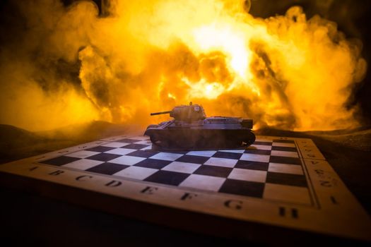War between Russia and Ukraine, conceptual image of war using chess board and tank on a dark background of explosion. Ukrainian and Russian crisis, political conflict. Selective focus