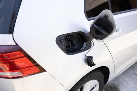 type 2 CCS plug port on electric vehicle. Fast charging socket type 2 combo electric car. DC - CCS type 2 EV charging connector at EV car. Eco friendly alternative energy green environment concept