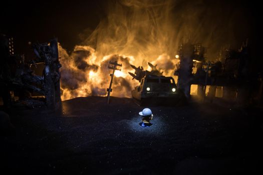 The death of children in the war. Russian war in Ukraine concept. Creative artwork of little doll lies on ground in burned out city. Selective focus