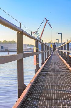 Wooden bridge at the beautiful wadden sea tidelands coast beach water and dike landscape panorama of the Harrier Sand island in Schwanewede Osterholz Lower Saxony Germany.