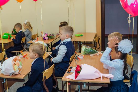 NOVOKUZNETSK, KEMEROVO REGION, RUSSIA - SEP, 1, 2021: First-grade students and teacher are in school classroom at first lesson. The day of knowledge in Russia.