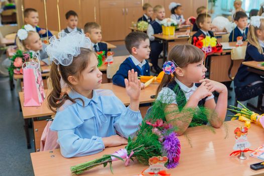 NOVOKUZNETSK, KEMEROVO REGION, RUSSIA - SEP, 1, 2021: First-grade students and teacher are in school classroom at first lesson. The day of knowledge in Russia.