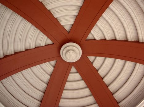 Underside of Dome with circle pattern and large red arches leading towards center with netting to protect from birds.  In San Jose, Costa Rica.