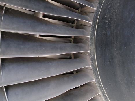 Close up of turbine and fan blades of a jet engine with signs of wear.