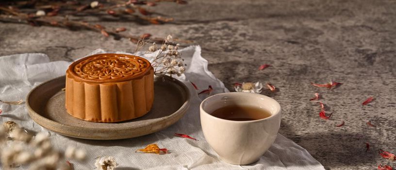 Mid Autumn moon cake and tea decoration with dried flower on stone table. Mid Autumn festival or Chinese traditional festival.