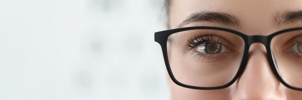 Close-up of woman face, female wear glasses for better vision with black frame. Bad sight, check eyes on oculist appointment. Optician, checkup concept