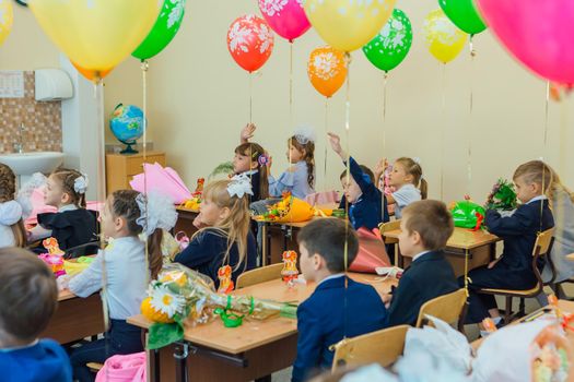 NOVOKUZNETSK, KEMEROVO REGION, RUSSIA - SEP, 1, 2021: First-grade students and teacher are in school classroom at first lesson. The day of knowledge in Russia.