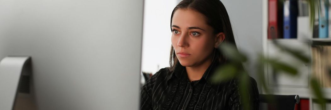 Portrait of young office worker stare at computer screen, search information online. Corporate clerk late at work, prepare report alone. Business concept